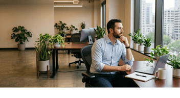 A man in an open office thinking about SEO, AEO, GEO, and ASO and what that means for his brand